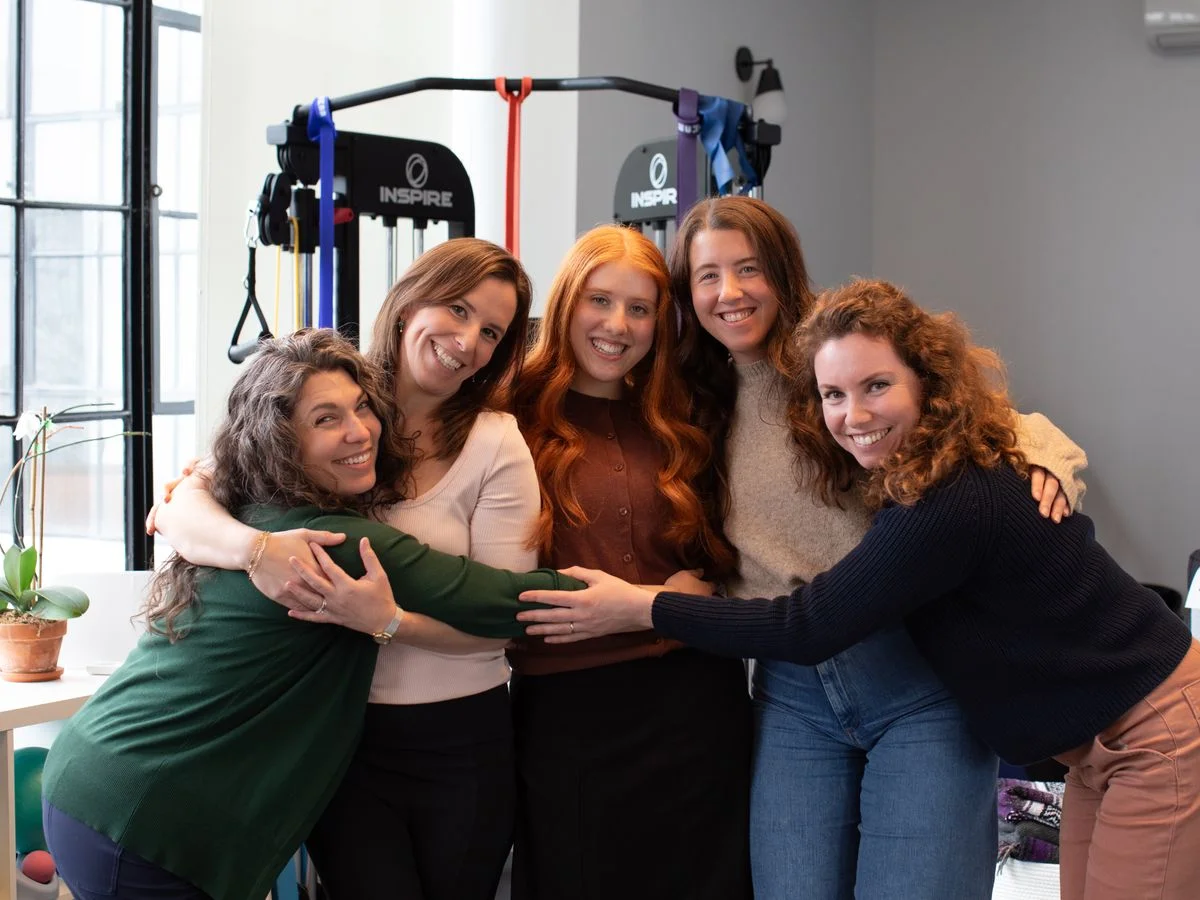 The Foundations Physical Therapy team laughing together in the clinic gym